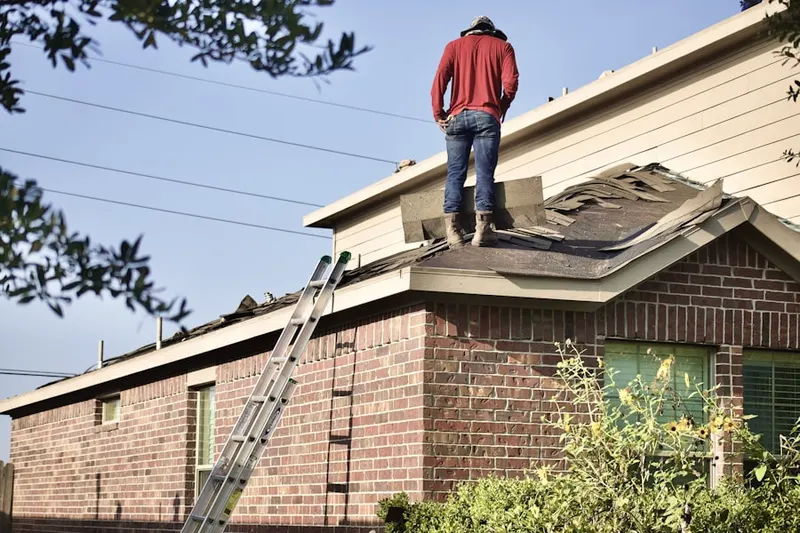 Professional roofer working on a residential roof in Purdy